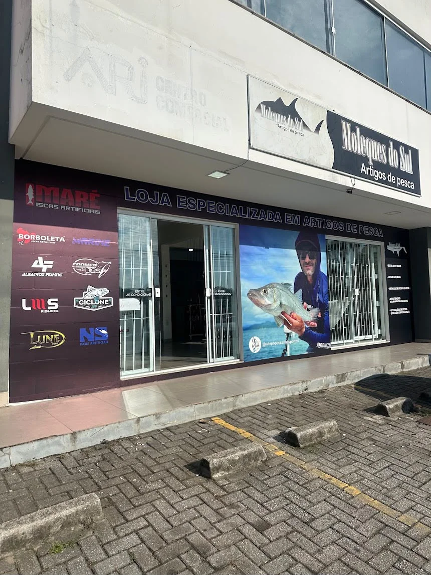 Fachada da Moleques do Sul: letreiro 'Moleques do Sul — Artigos de pesca' e vitrine com as marcas Maré, Borboleta, Marine, Albatroz, Cromer, Lumis, Ciclone, Lune e NS